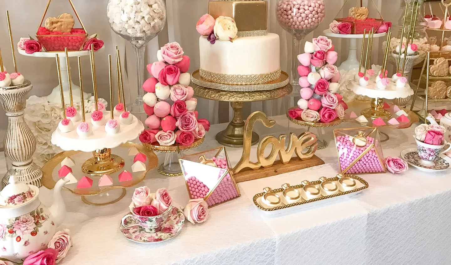 Sweet Mood wedding candy and dessert table with pink candy jars, floral sweets, gold display stands and a white celebration cake